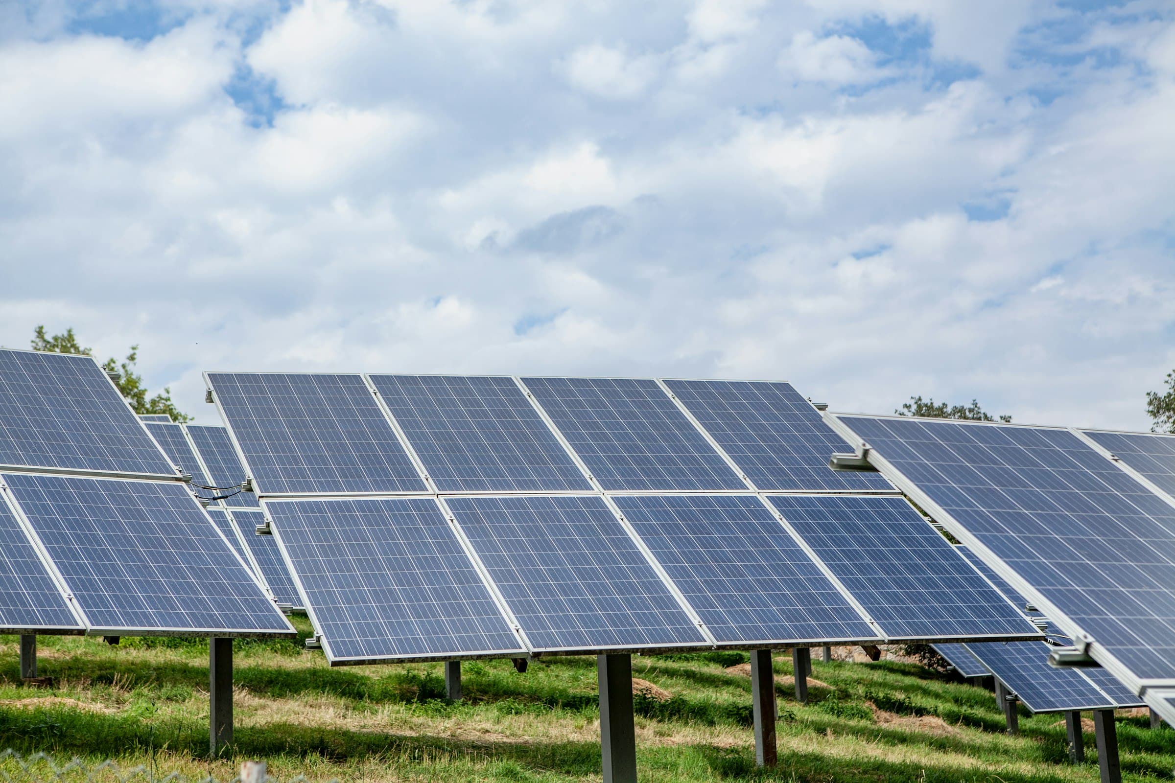 A ground-mounted photovoltaic array in tilted rows across open ground.
